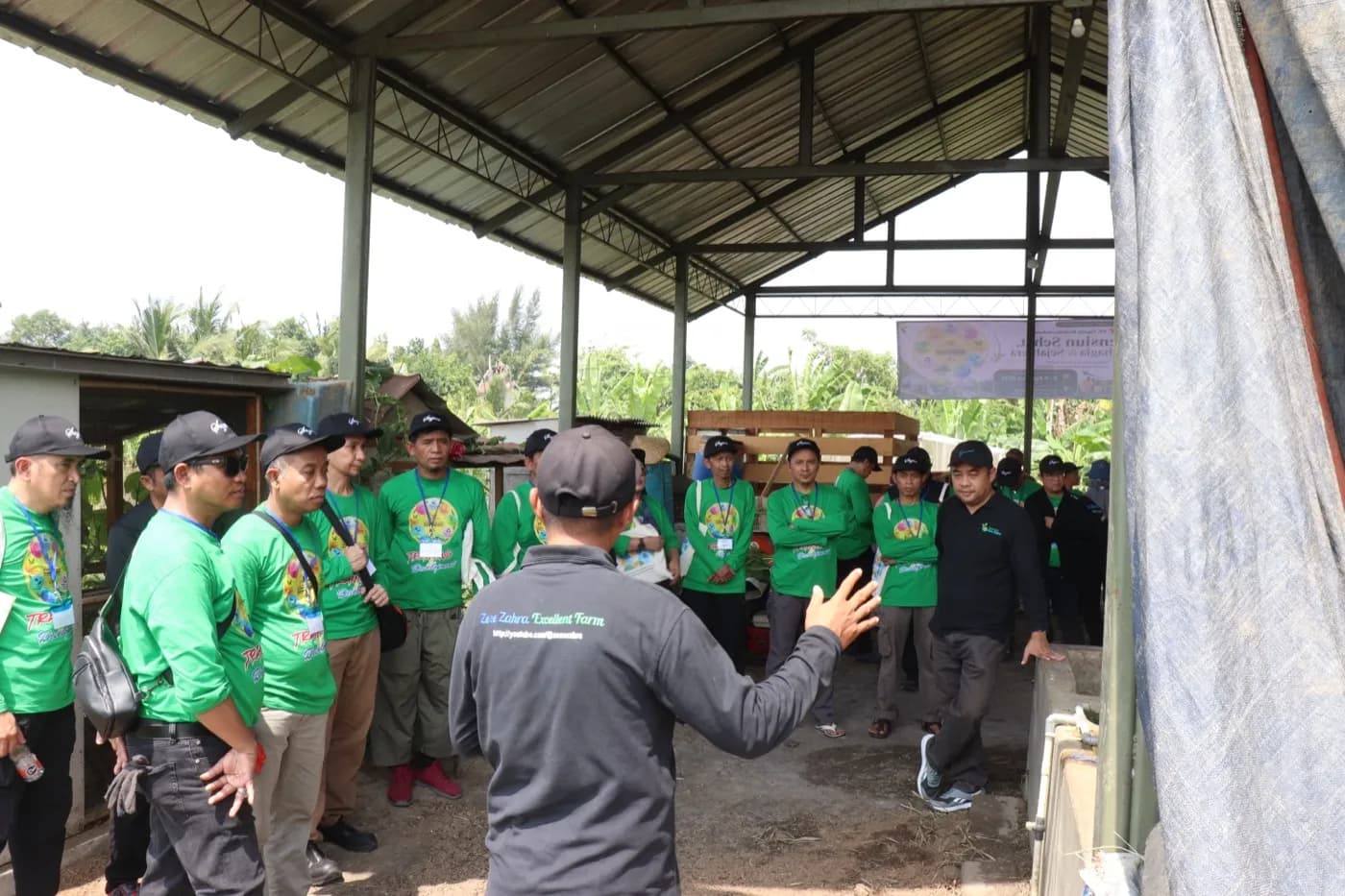 Pemandu kebun menjelaskan kepada peserta di area kandang